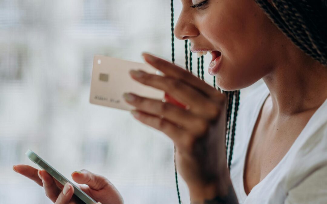 An African American woman talking on the phone about her credit card.